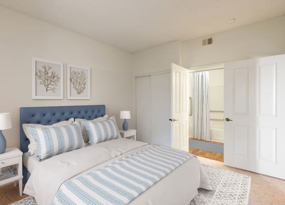Retirement Homes in Ventura, CA - Cypress Meadows - Bedroom with Closet Sliding Doors, Connected Bathroom, and Blue Decorative Bedding