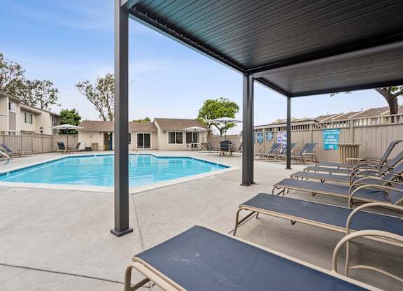 A pool with a blue cover and a metal bench.