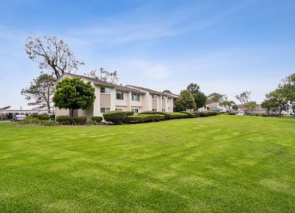 A large grassy field in front of a building.