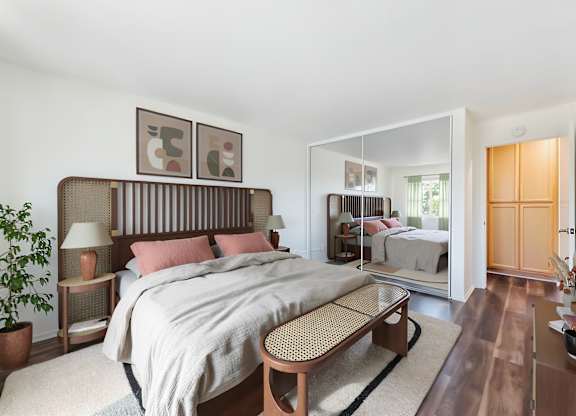 A bedroom with a large bed and a mirror on the wall.