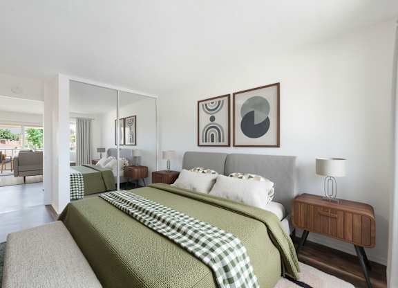 A bedroom with a large bed and a green blanket.