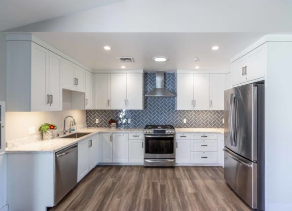a kitchen with white cabinets and stainless steel appliances