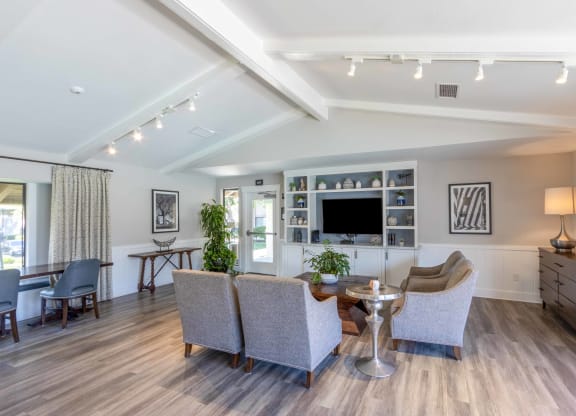 a living room with couches and chairs and a tv