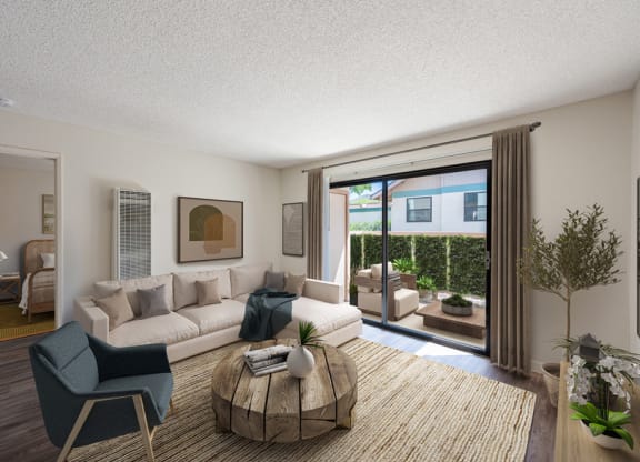 Apartments Near Vandenberg Air Force Base - Knollwood Meadows - Living Room With Plank Flooring, Area Rug, Sectional Couch, Armchair, Round Coffee Table, Wall Art, House Plant, and Sliding Glass Door with Access To Patio