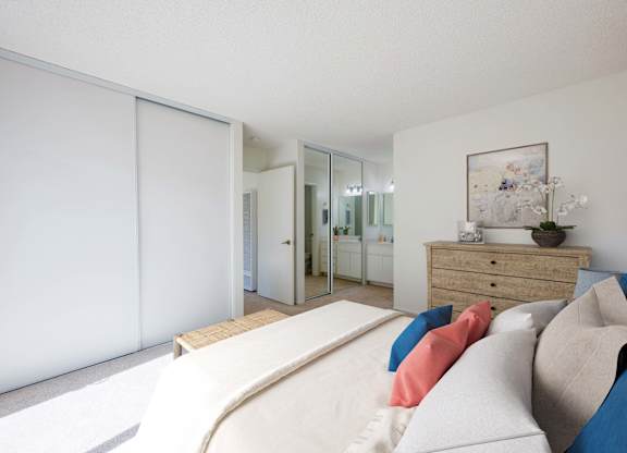 A bedroom with a bed, dresser, and mirror.