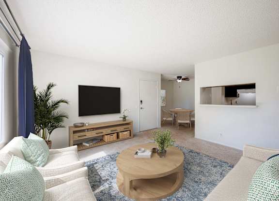 A living room with a white couch and a wooden coffee table.