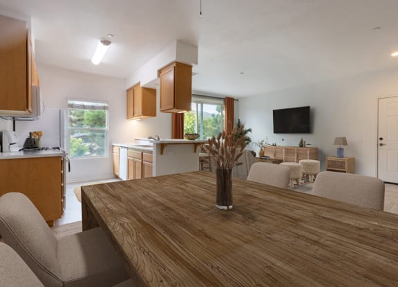 a dining room and living room with a wooden table and chairs