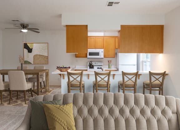 a living room with a couch and a kitchen with a table and chairs