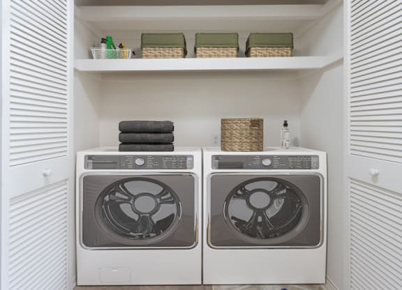 Lompoc, CA, Apartments Near Walmart - Oceanwood - Laundry Closet with Washer, Dryer, Shelves, and Baskets.