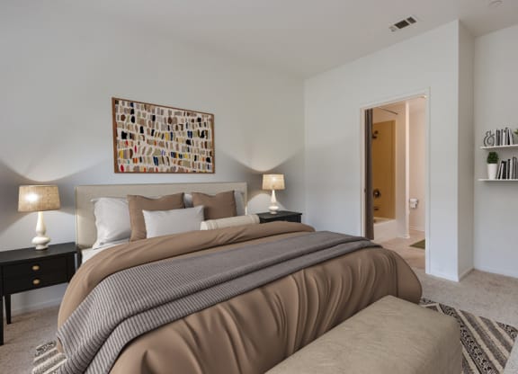 a bedroom with a large bed and a door to a bathroom