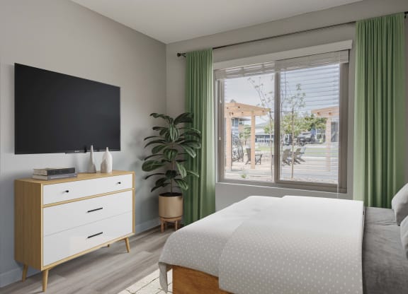 a bedroom with a bed and a tv and a window