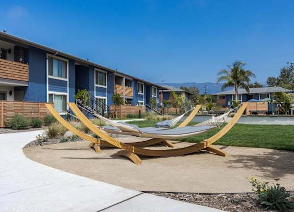 a pair of hammocks in front of some apartments