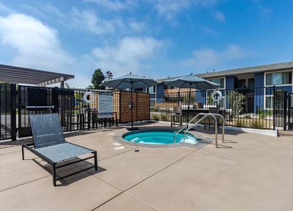 our apartments have a hot tub and a patio with chairs and umbrellas