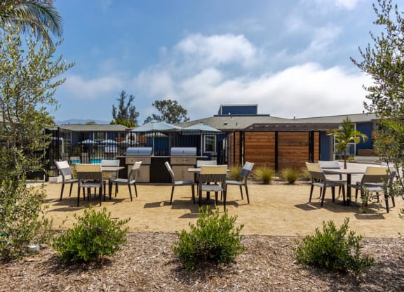 a patio with tables and chairs and a building in the background