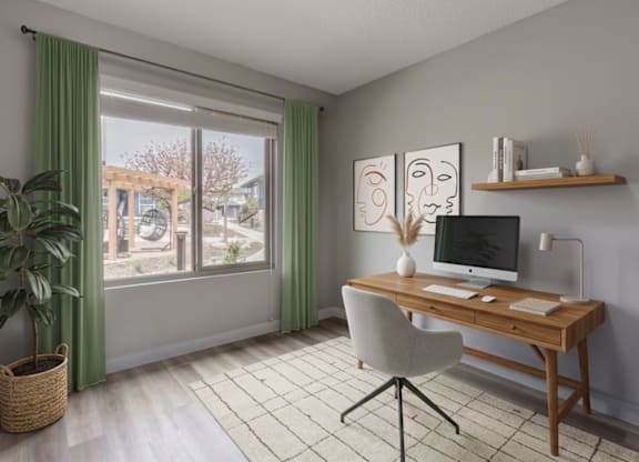 A room with a desk, chair, and a plant.