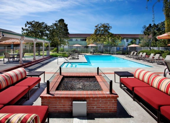 a pool with red and white lounge chairs and a swimming pool