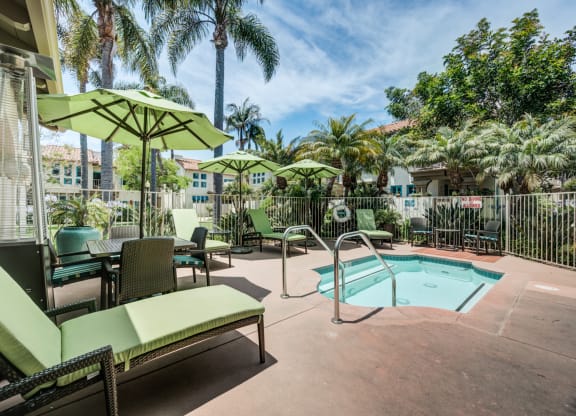 1-Bedroom Apartments in Santa Barbara, CA - Rancho Franciscan - Hot Tub, Green Lounge Seats, Green Umbrellas with Tables and Chairs, Lush Landscaping, and Standing Outdoor Glass Tube Patio Heater