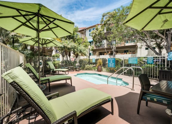 a pool with lounge chairs and umbrellas