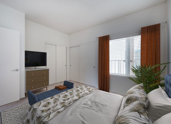 One-Bedroom Apartments in Santa Barbara, CA - Rancho Franciscan - Bedroom With Bed, Carpeting, Two Large Closets, Dresser, TV, Bench, and Large Window With Blinds and Coverings