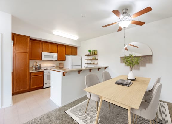 Apartments in Santa Maria, CA, for Rent - Siena - Dining Room with Carpeted Floor, Dining Table with 4 Chairs, Ceiling Fan, and View of Kitchen