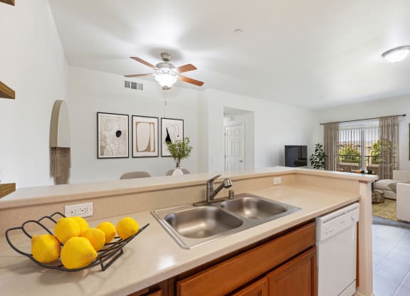 a kitchen with a sink and a ceiling fan