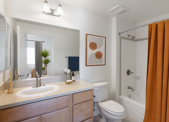 a bathroom with a white sink and toilet next to a white bathtub with a shower curtain