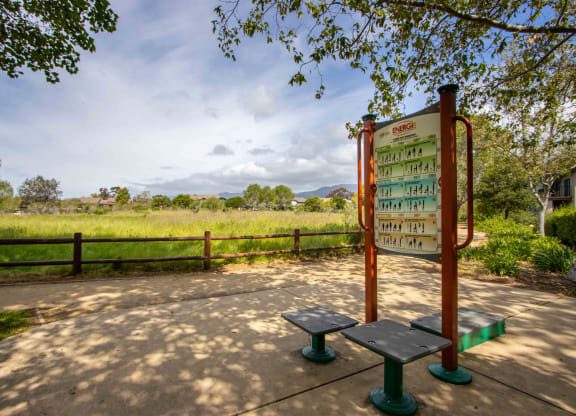 a bench and a sign next to a field