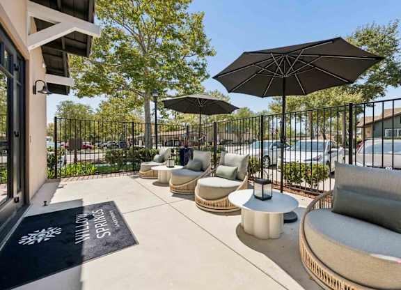 A patio area with a black umbrella and a sign that says "Spacial".
