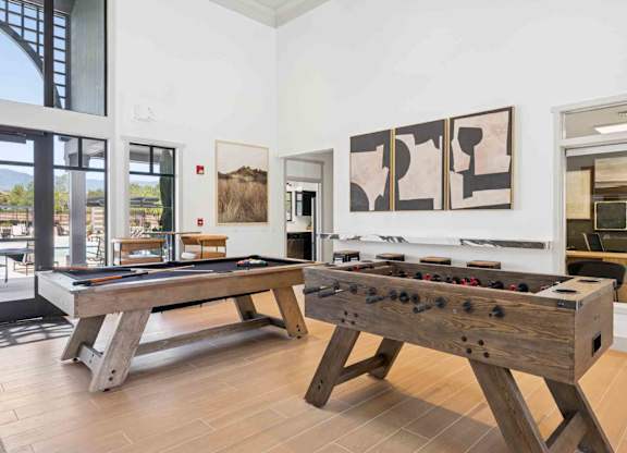 A pool table and air hockey table in a room with white walls.