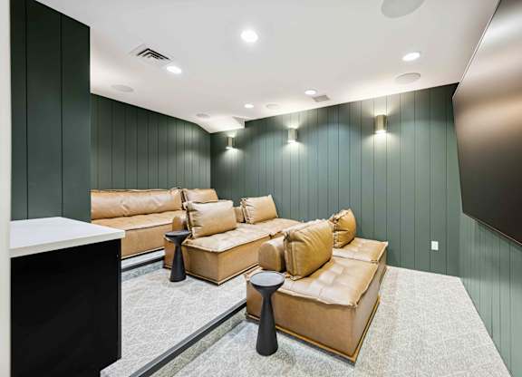 A living room with a tan couch and a black coffee table.