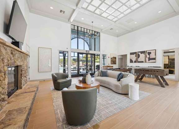 A living room with a stone fireplace and a large grey sofa.