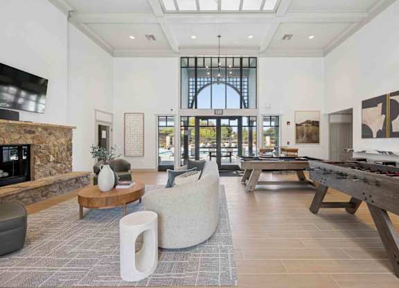 A modern living room with a stone fireplace and a large window.