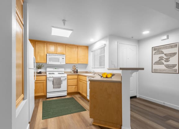 Goleta, CA, Apartments Near Starbucks - Willow Springs - Kitchen with Wood-Style Flooring, Breakfast Bar, Tan Cabinets and White Appliances