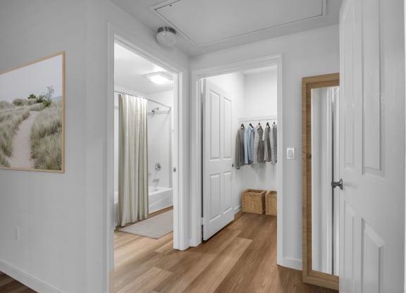 a hallway with a door to a closet and a bathroom with a shower