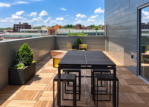 A table and chairs are set on a wooden deck.