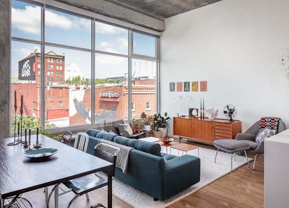 A living room with a view of the city through large windows.