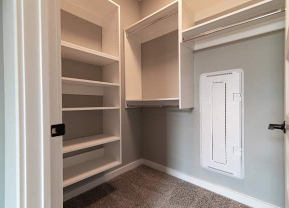 A white pantry with a white door and shelves.