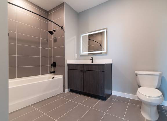 A bathroom with a white toilet and a white bathtub.