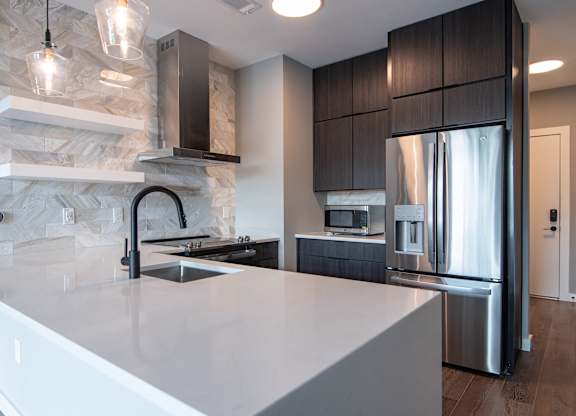 A modern kitchen with a marble backsplash and stainless steel appliances.