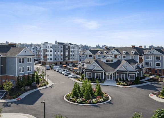 A large parking lot in front of a row of houses.