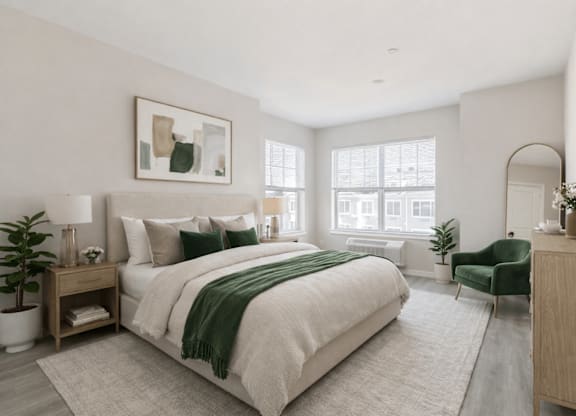 A bedroom with a large bed and a green chair.