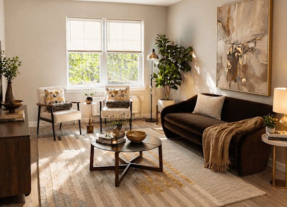 A living room with a brown couch, a coffee table, and a large painting on the wall.