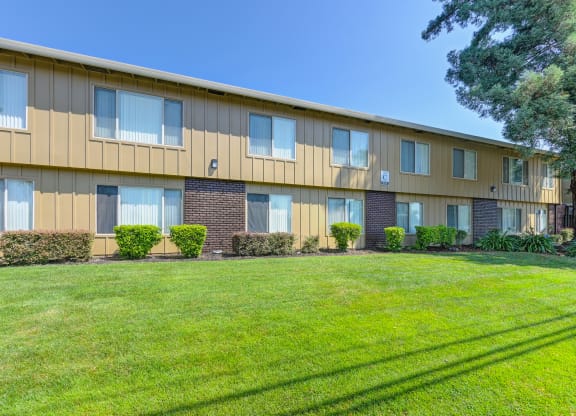 Asbury Place Apartment buildings with green grass outside and large trees