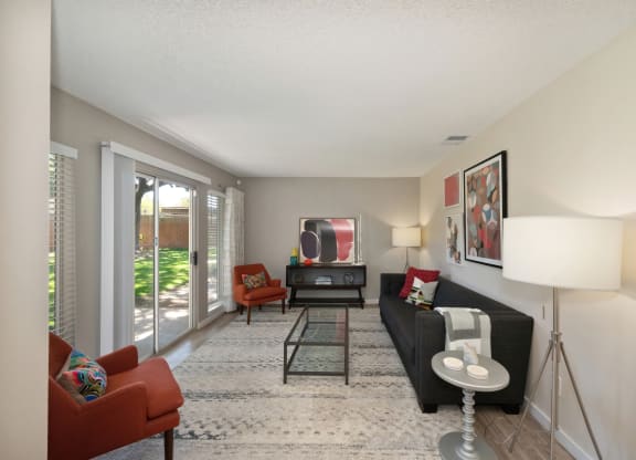 a living room with a couch and chairs and a tv