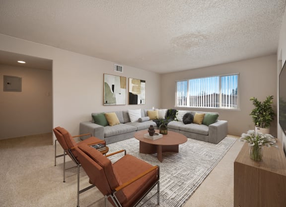 the living room of an apartment with a couch and chairs