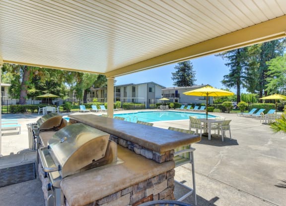 BBQ Area at Pool with Chairs, Tables and Patio Umbrellas at Renaissance Park Apartments, California, 95618