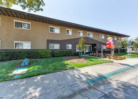 Building Entrance with Grass, Walkways and Tree  at Olympus Park Apartments, Roseville, CA