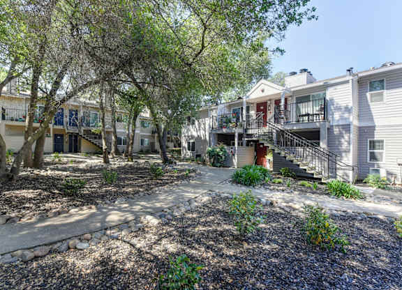 Apartment Exterior with Trees, Bushes and Walkway at Hidden Oaks Apartments, California