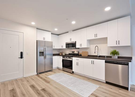 A modern kitchen with stainless steel appliances and white cabinets.