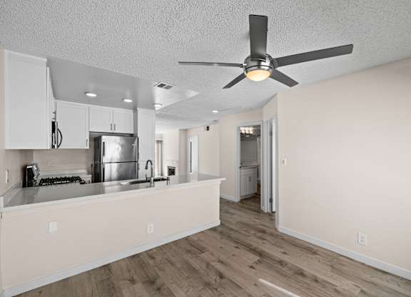 A kitchen with a fan on the ceiling.